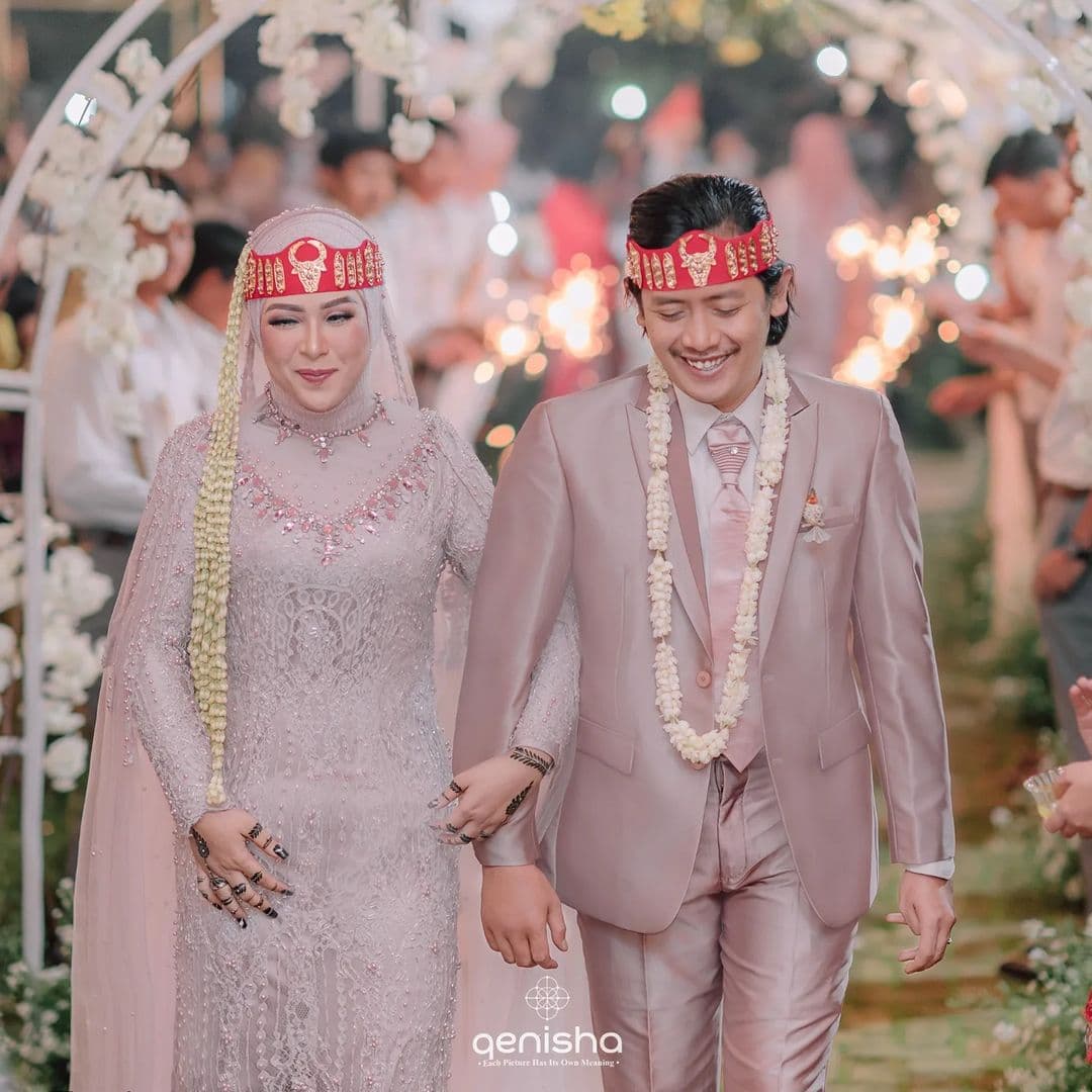 Pasangan pengantin berjalan di resepsi pernikahan TASA